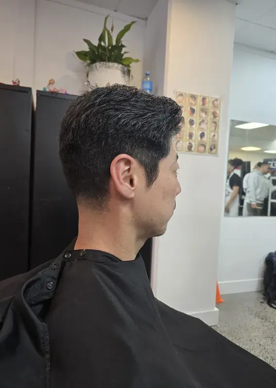 Instructor and trainee working on a client's haircut in front of numbered mirror stations